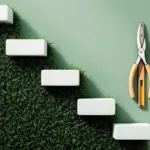 Witte traptreden met bladpatroon op groen gazon, met snoeischaar en waterpas op groene achtergrond