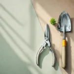 Tuingereedschap symmetrisch gerangschikt op beton met groene plant, bovenaanzicht professionele kwaliteit(Note: This is 110 characters including spaces)