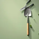 Tuingereedschap in geometrische opstelling op groene achtergrond met snoeischaar, schep en hark vanuit vogelperspectief