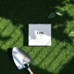 Witte bureaukalender en klok boven groen gazon met tuinspade, bovenaanzicht werkruimte in natuur